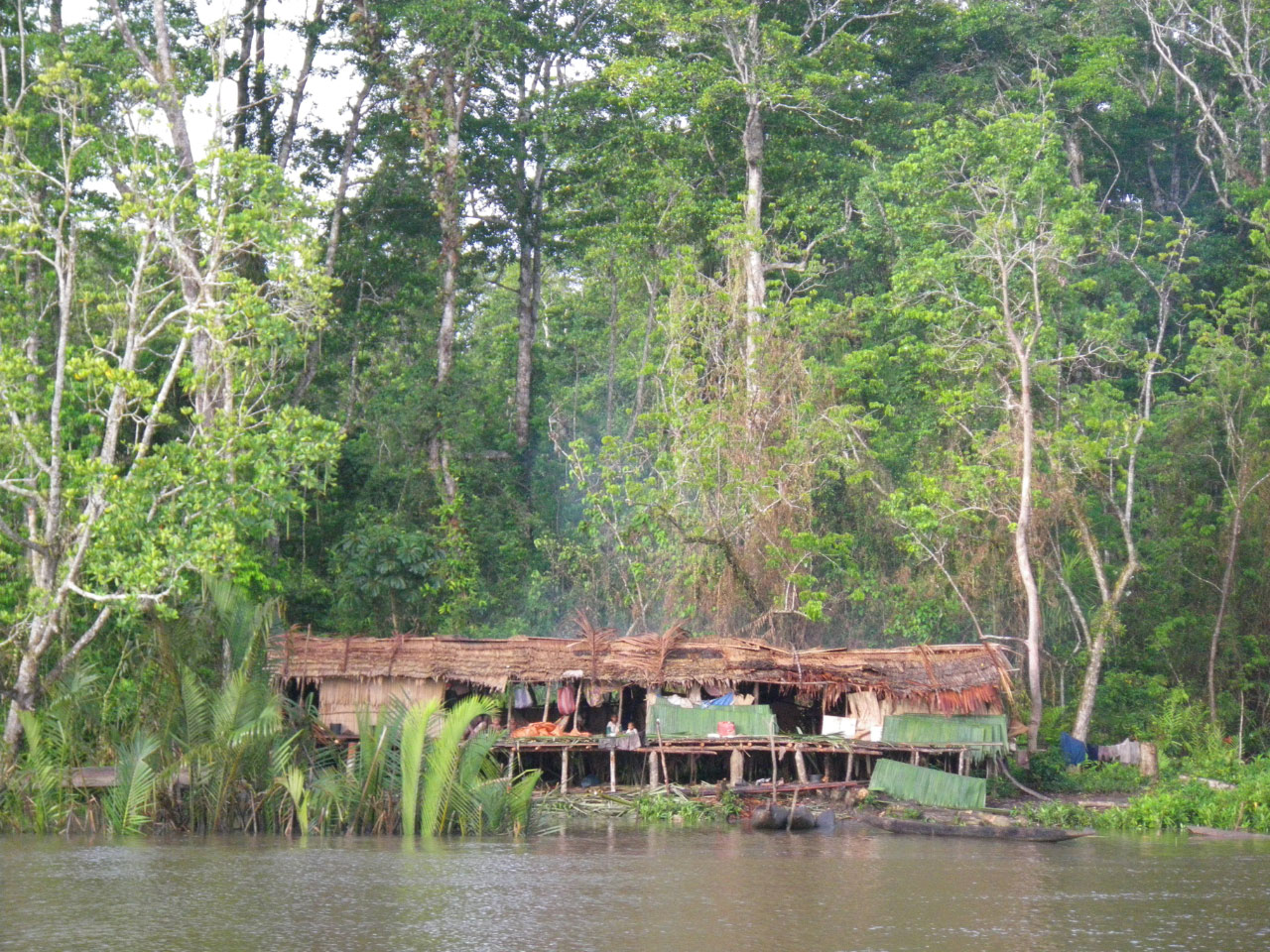 légende village Asmat si pilotis en bord de fleuve
