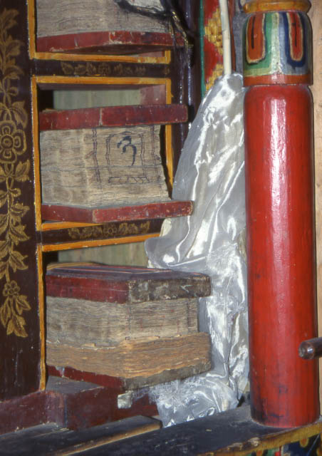 Livre tibetain: feuilles libres empilées entre deux planches sculptées livre